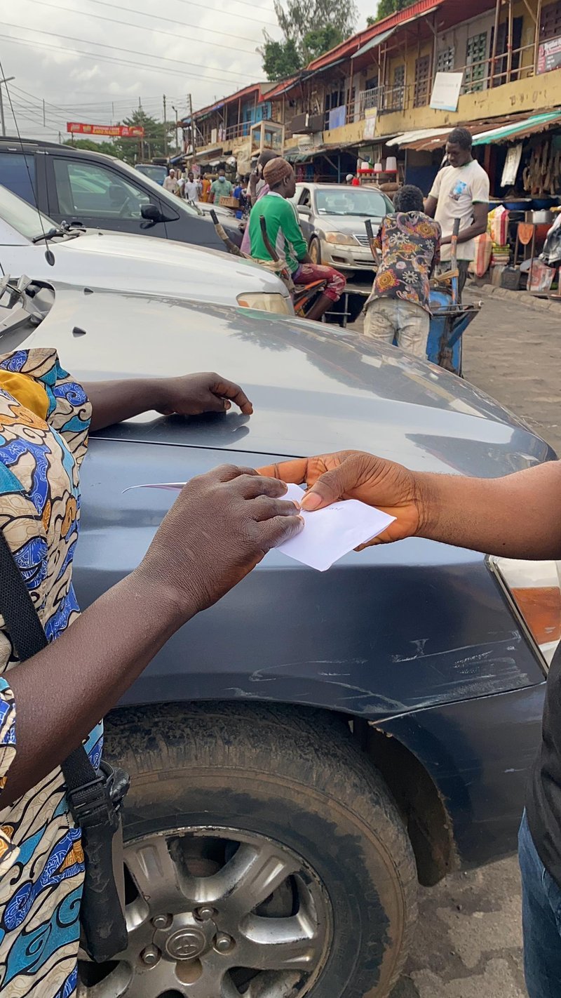 Cash gift being handed to a street hawker